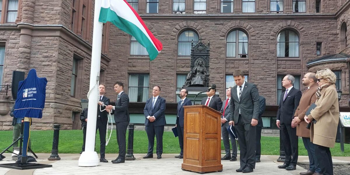 Dr. Gábor Péter Artner, Deputy CEO of the Hungarian Export Promotion Agency (HEPA), and Dr. János Jákó, Consul General of Hungary in Toronto, raising the Hungarian flag in front of the Ontario Provincial Parliament to commemorate the 1956 Hungarian Revolution.