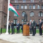 Dr. Gábor Péter Artner, Deputy CEO of the Hungarian Export Promotion Agency (HEPA), and Dr. János Jákó, Consul General of Hungary in Toronto, raising the Hungarian flag in front of the Ontario Provincial Parliament to commemorate the 1956 Hungarian Revolution.