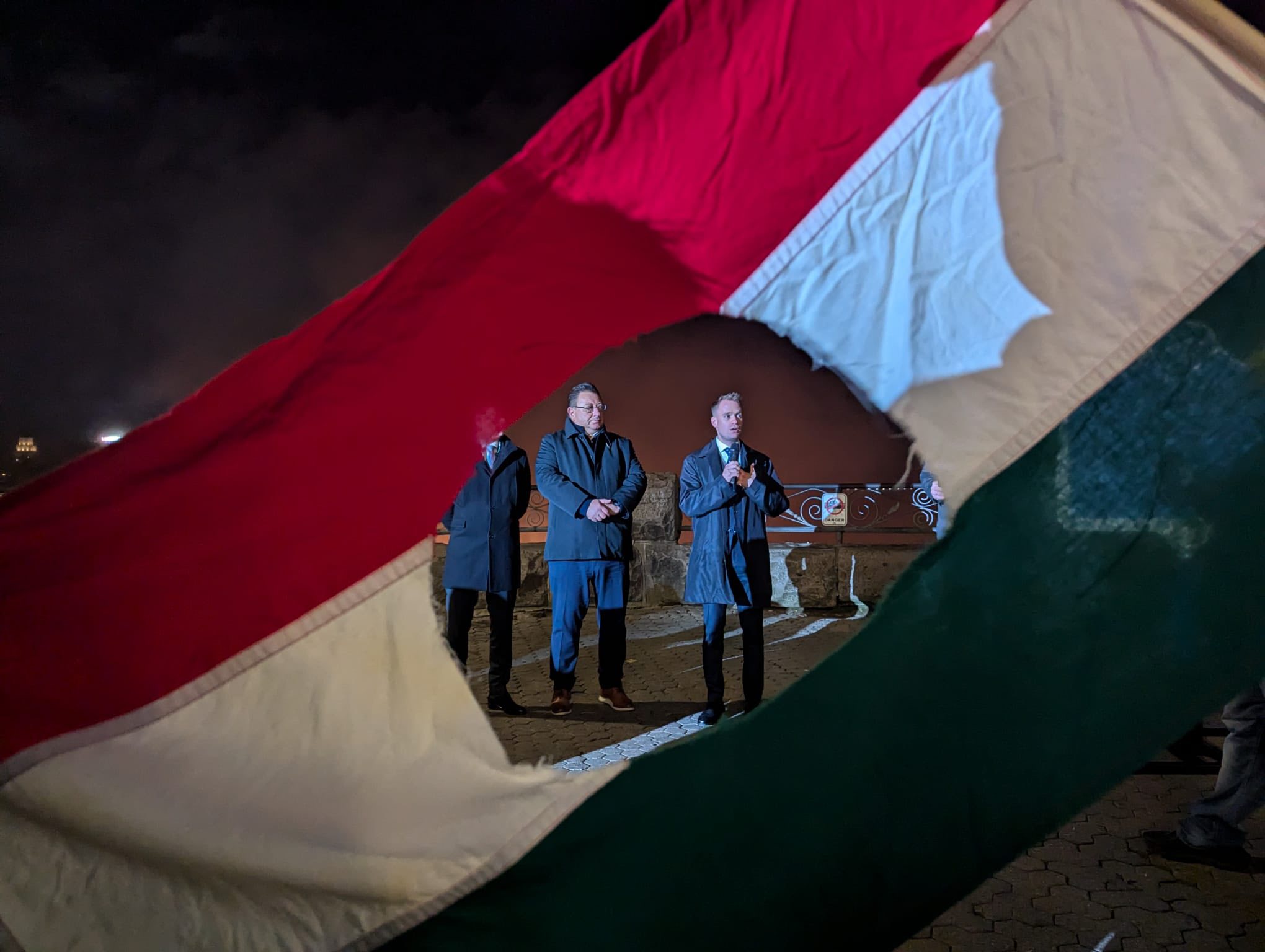 Sandor Balla, Executive Director of the HEPA Regional Office Canada, and Dr. Gábor Péter Artner, Deputy CEO of HEPA, delivering a speech at Niagara Falls through the symbolic ’56 hole in the Hungarian flag during the 1956 Revolution commemoration.