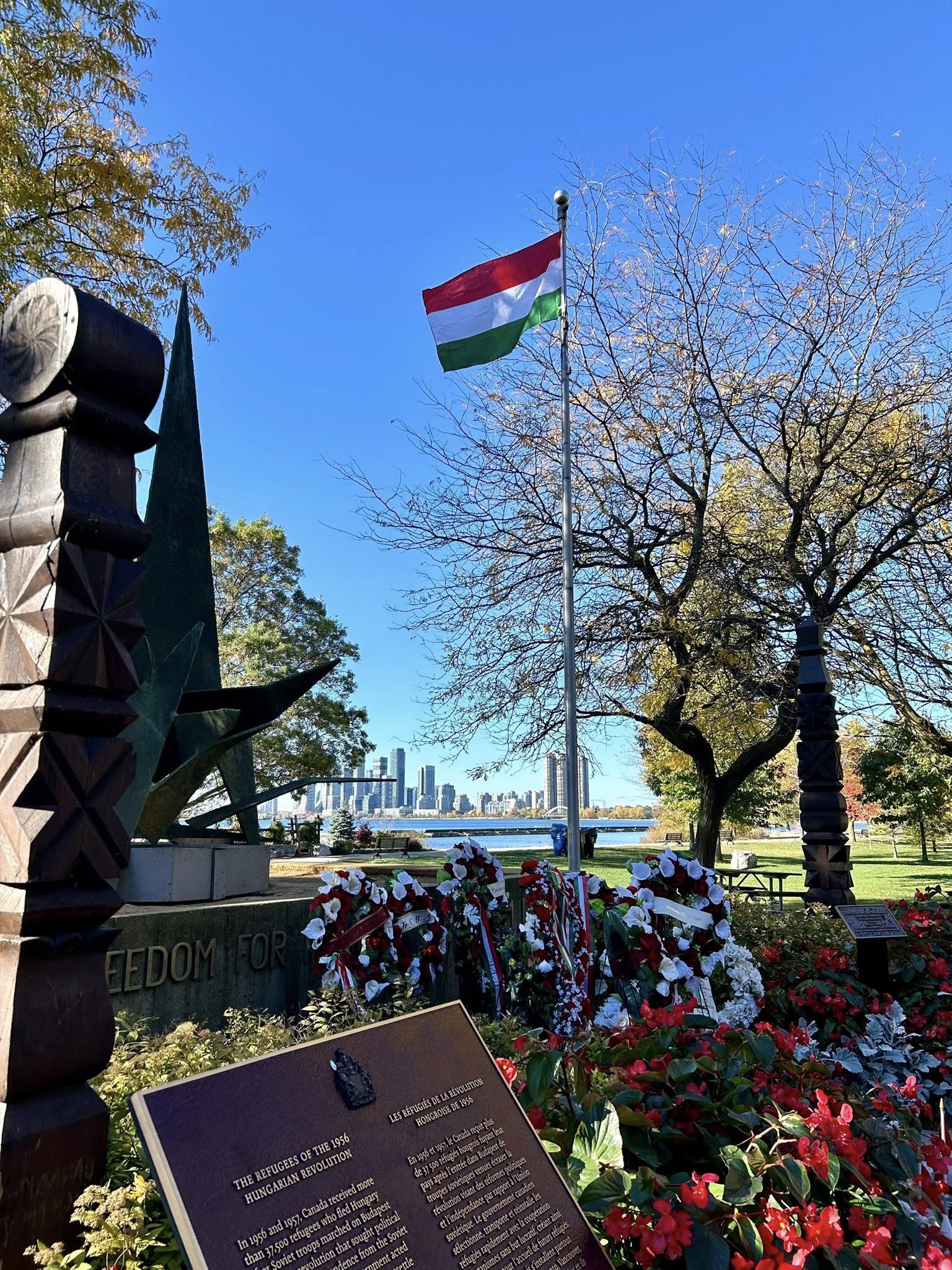 Hungarian national flag displayed with wreaths of remembrance at Budapest Park, Toronto, honoring the heroes of the 1956 Hungarian Revolution.